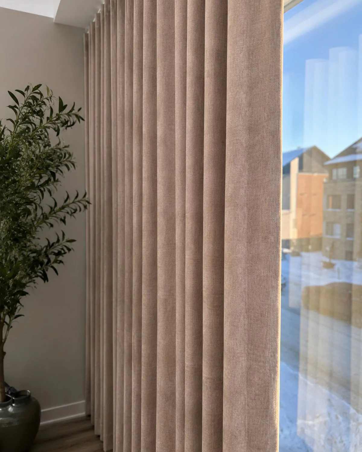Blackout wave-pleat drapes drawn across a bedroom window